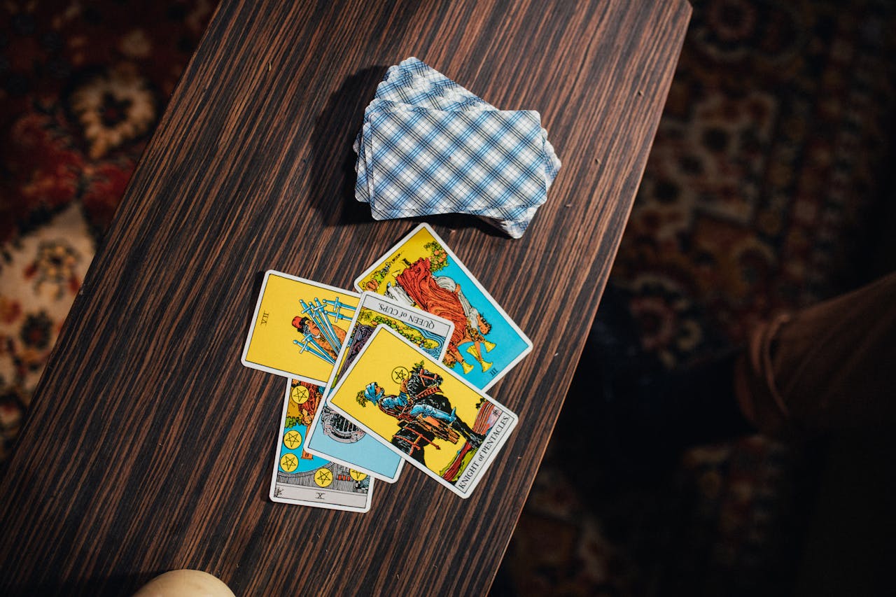 A flat lay of tarot cards for fortune telling on a wooden table.